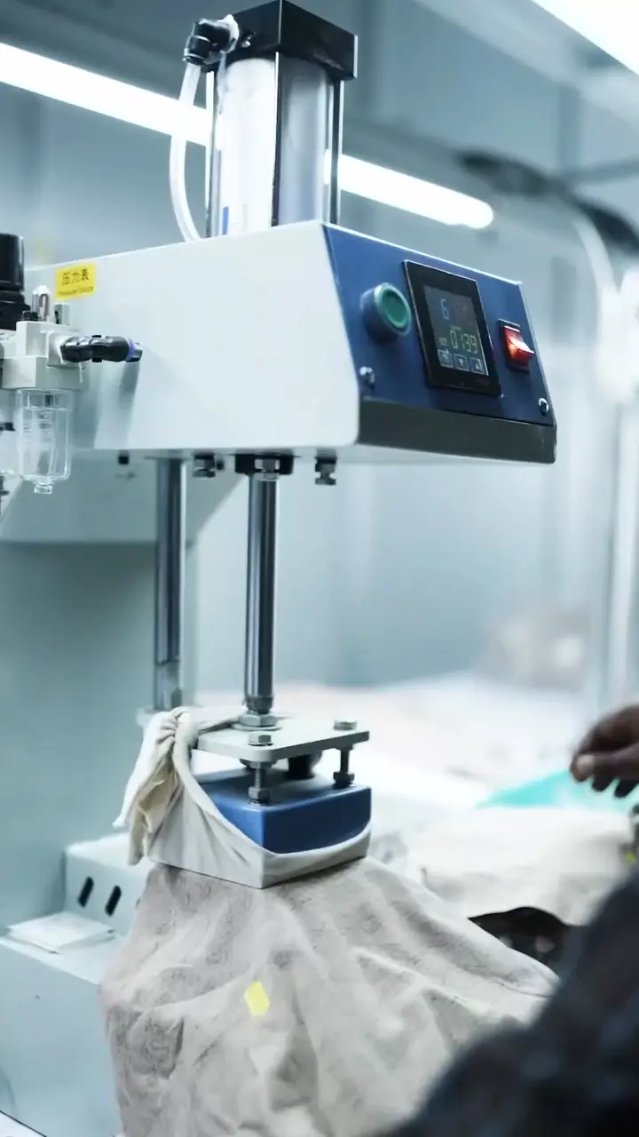 An automated pad printing machine stamping custom private label branding inside a blank t-shirt neck