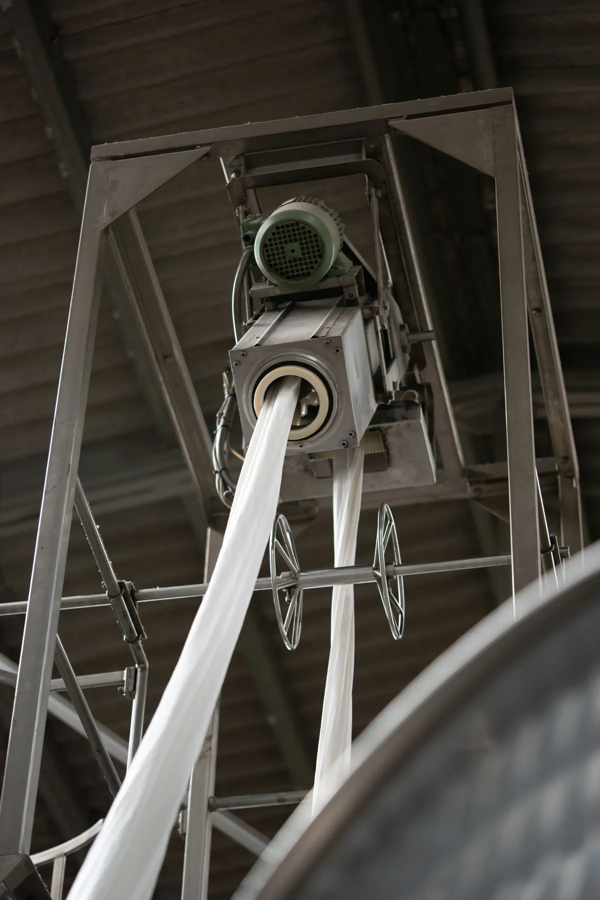 A commercial continuous tumble dryer processing fabric rolls at a textile finishing mill