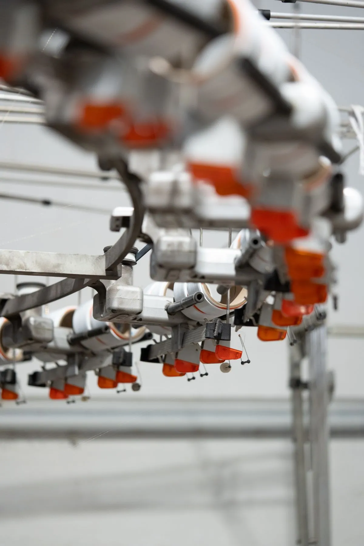 Close-up view of a precision circular knitting machine weaving combed cotton yarn into jersey fabric
