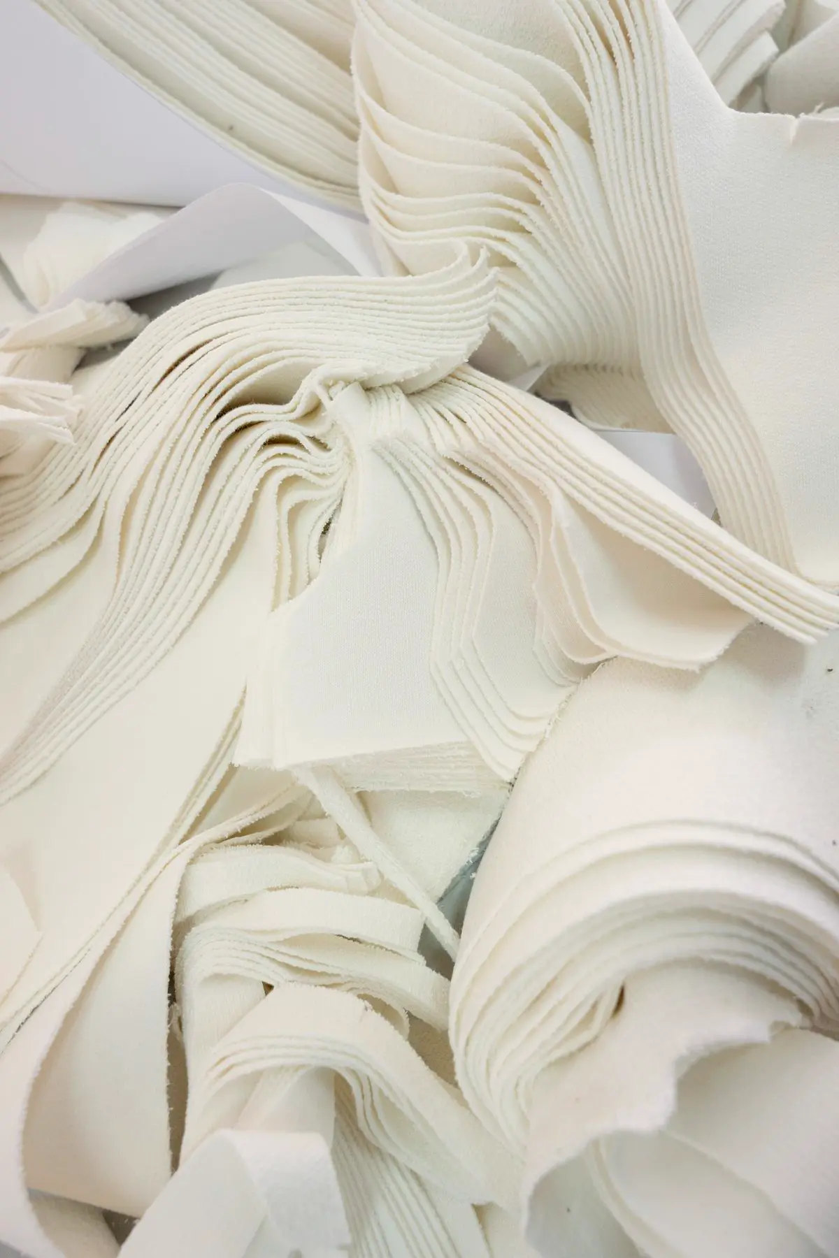 Close-up view of a raw textile panel being cut precisely according to custom garment tech pack measurements